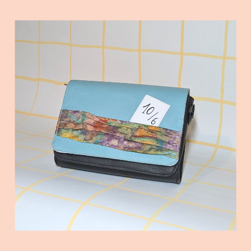 Godot-San maroquinerie rabat "chapelier fou" monté sur poche noire. fond vert d'eau, empiècement tissus type foulard que l'on trouve sur le rebord du chapeau, carte 10/6 en cuir cousues et breloque lapin en métal.