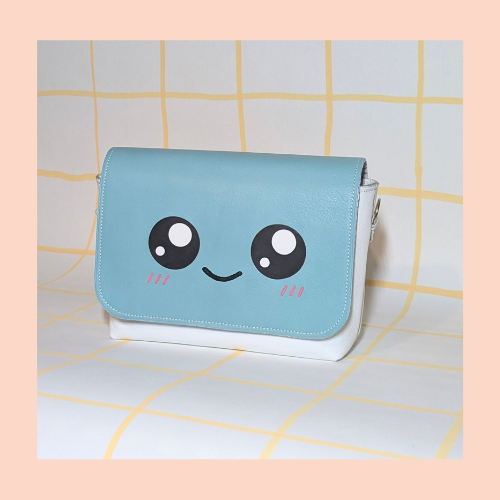 rabat kawaii couleur vert d'eau. sourire kawaii, marqueterie pour les yeux et le rose des pommettes au feutre cuir pour le sourire monté sur une poche blanche.