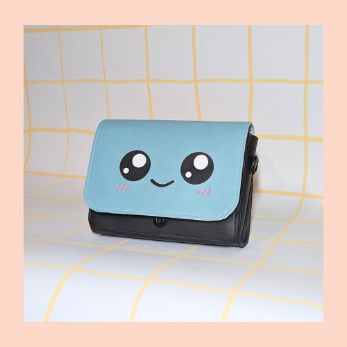 rabat kawaii couleur vert d'eau. sourire kawaii, marqueterie pour les yeux et le rose des pommettes au feutre cuir pour le sourire monté sur une poche noire.